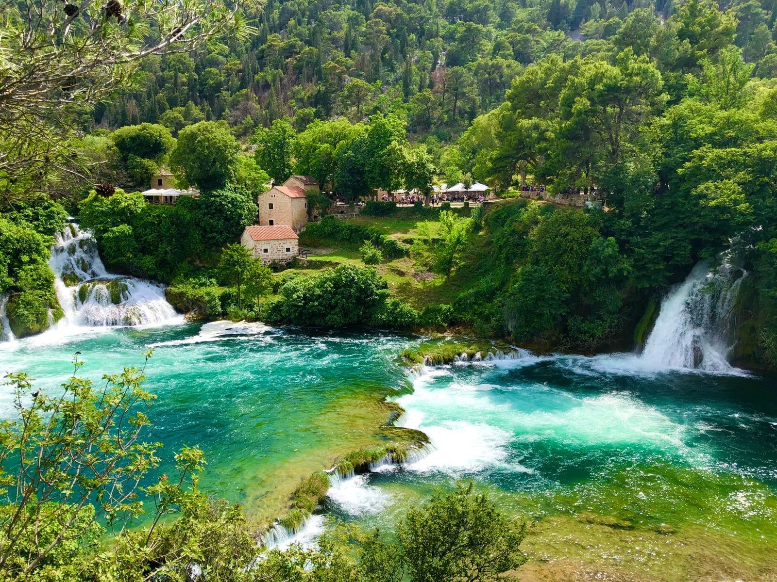 Bassins turquoise et cascades en gradins bordant des moulins à eau historiques en pierre à Roški slap dans le parc national de Krka.