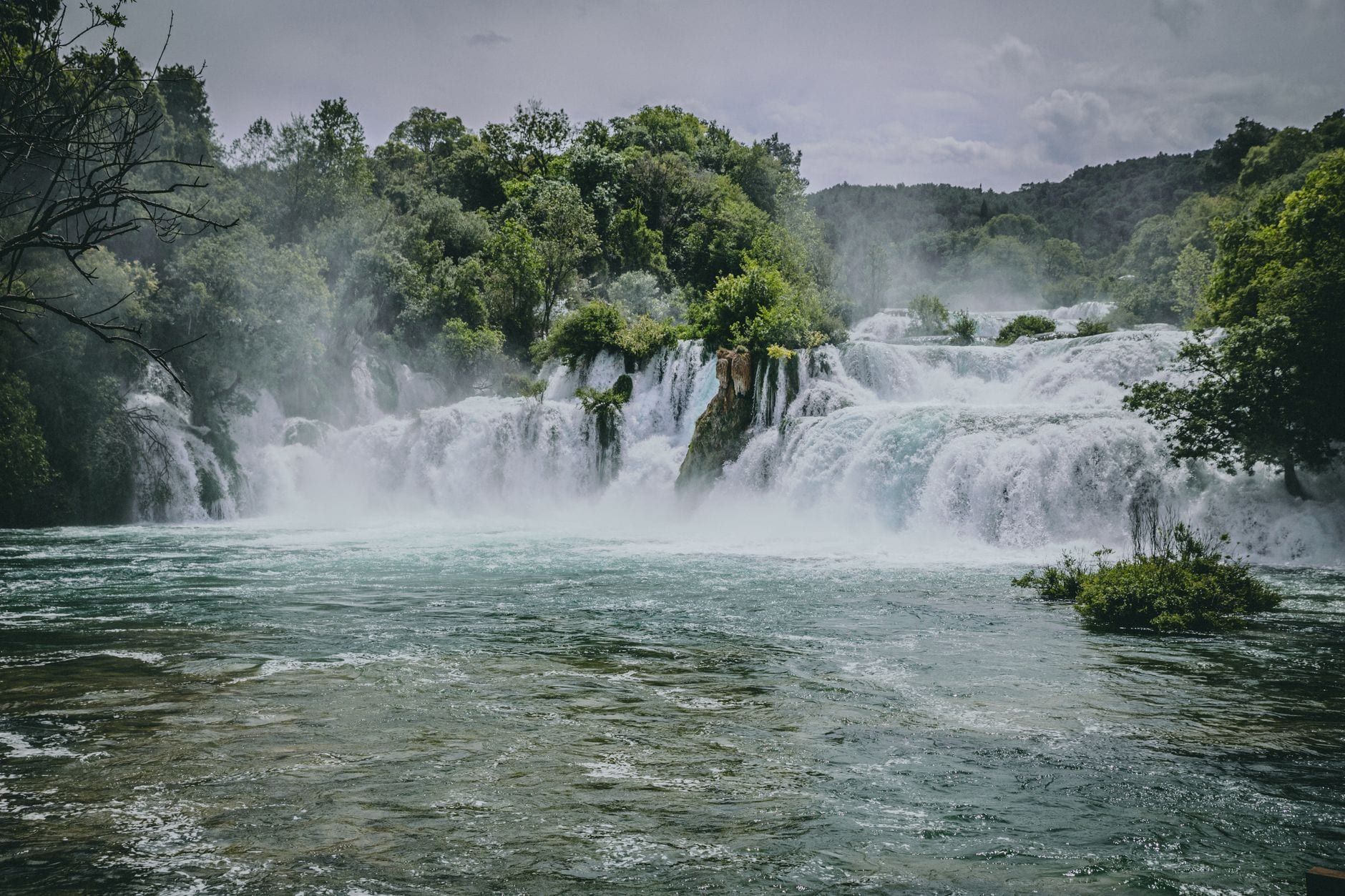 Kaskadierende Stufen des Wasserfalls Skradinski Buk, umgeben von dichtem grünem Wald im Nationalpark Krka.