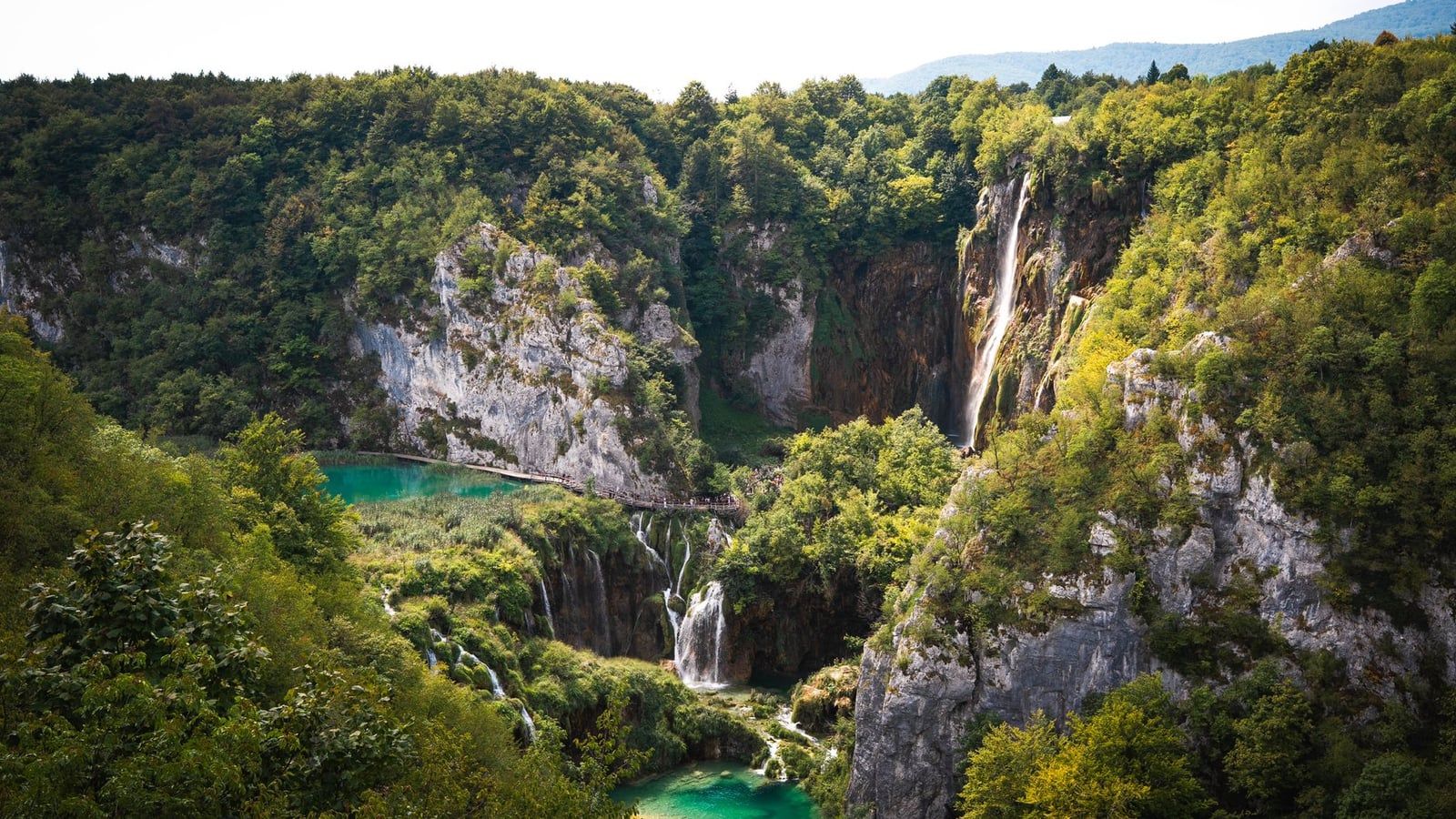Veliki Slap waterfall plunges down steep limestone cliffs into the canyon and turquoise lakes at Plitvice Lakes National Park.